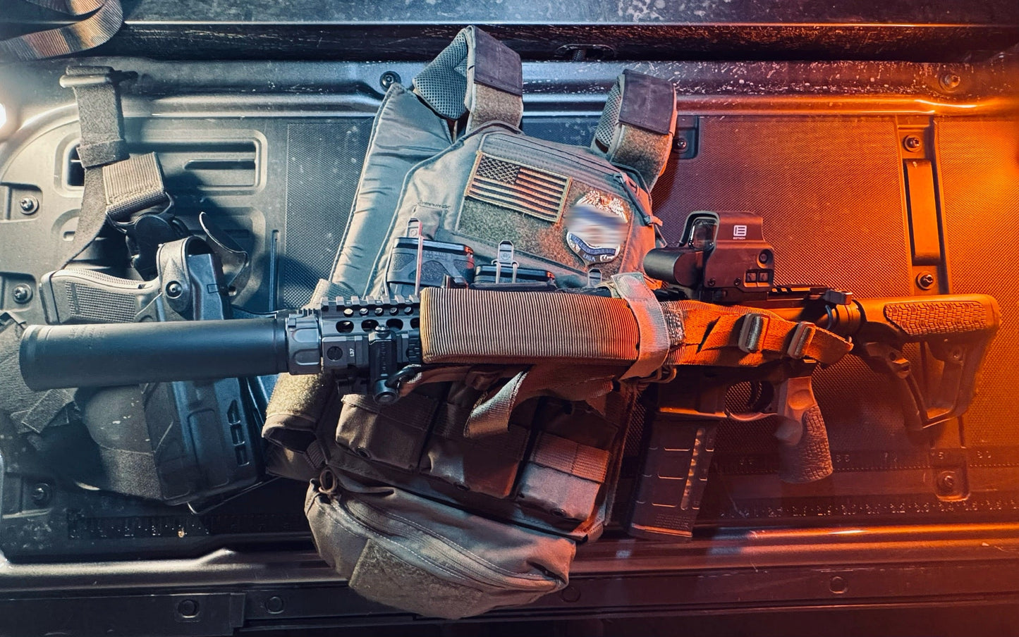Rifle with tactical plate carrier with flex badge on a vehicle's open door