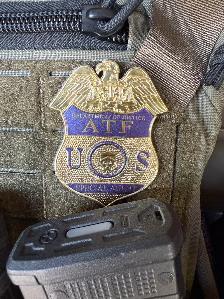 ATF Special Agent flex shield badge on a tactical vest with a gun visible below.