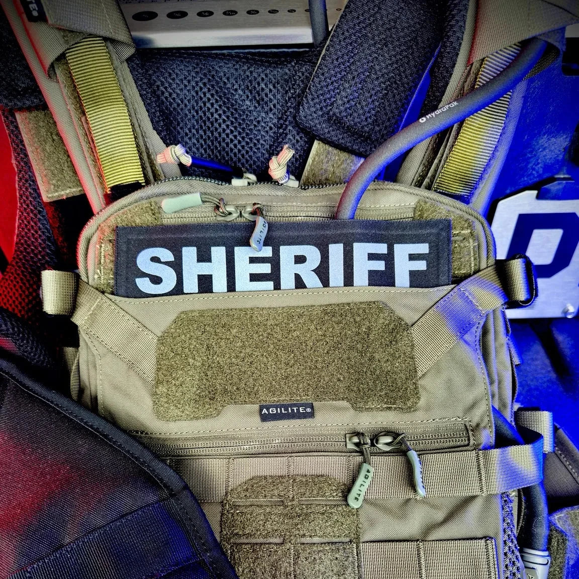 Tactical pouch with 'SHERIFF' patch on a blue background
