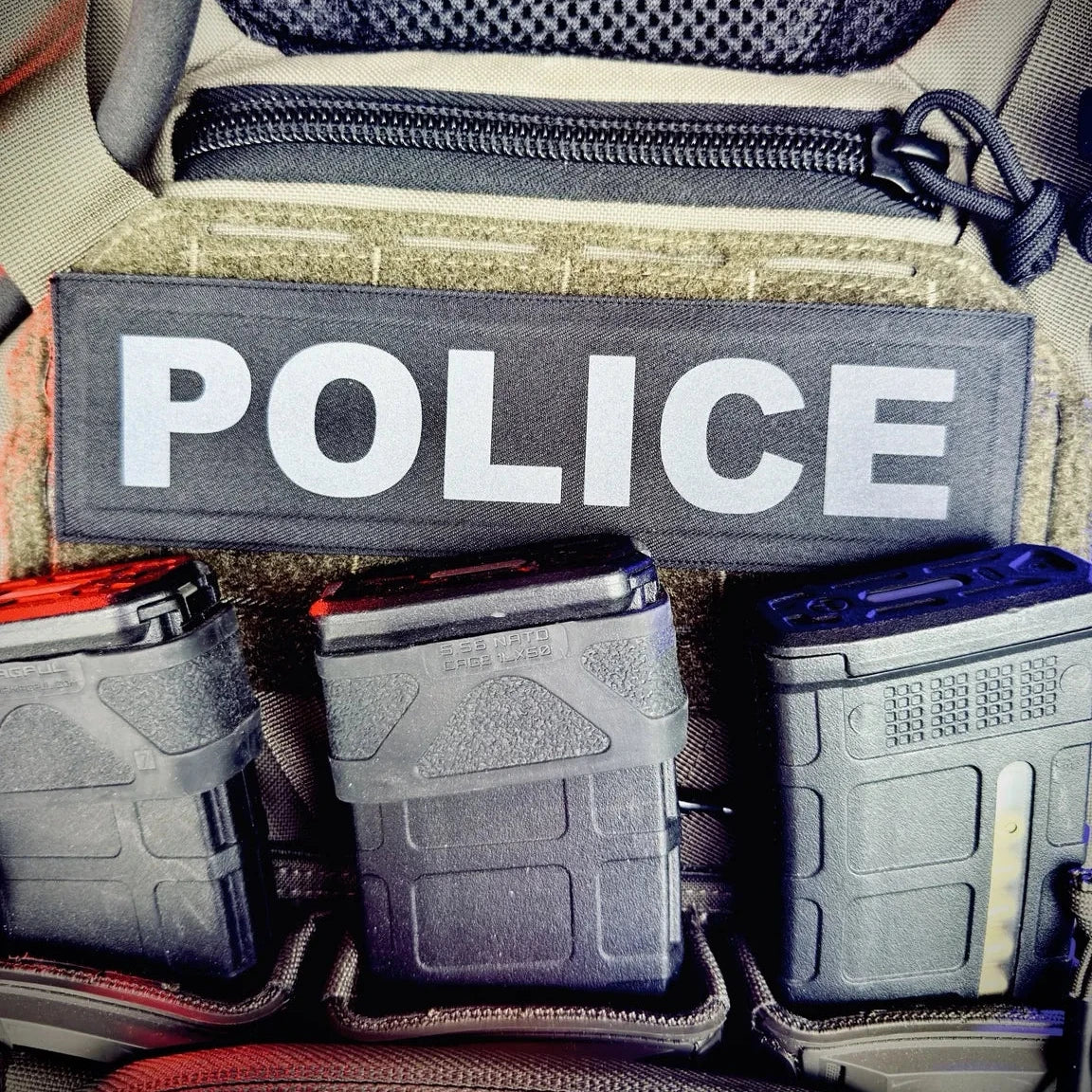 Police tactical pouch with magazines and 'POLICE' patch inside a vehicle.
