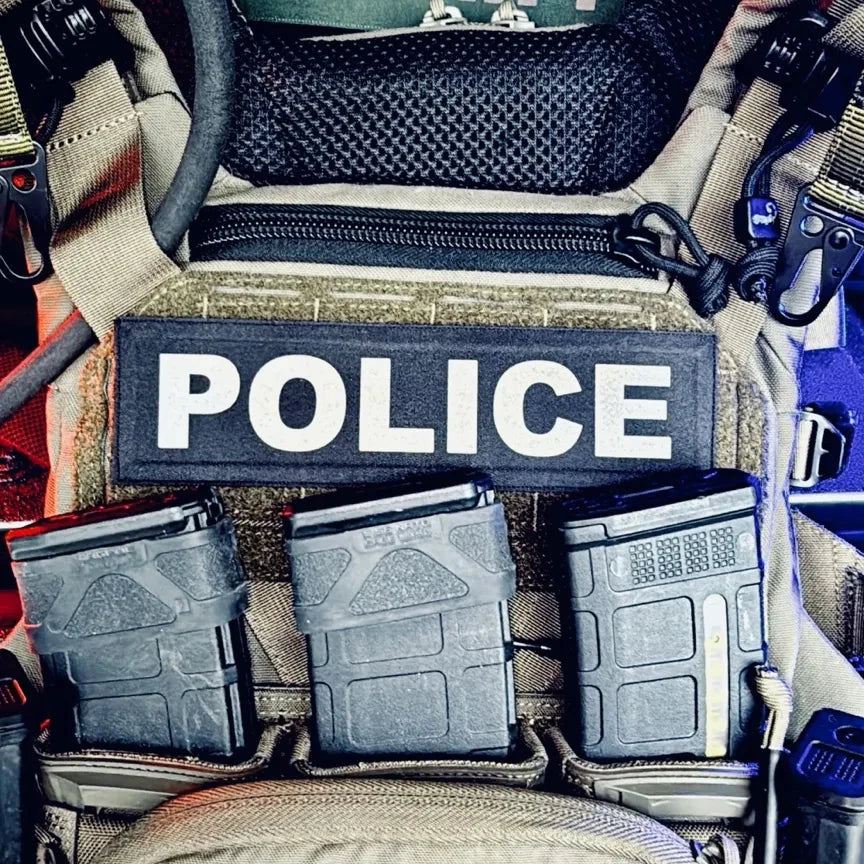 Police vehicle interior with tactical gear and 'Sheriff' sign.