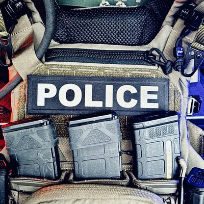 Police vehicle interior with tactical gear and 'Sheriff' sign.