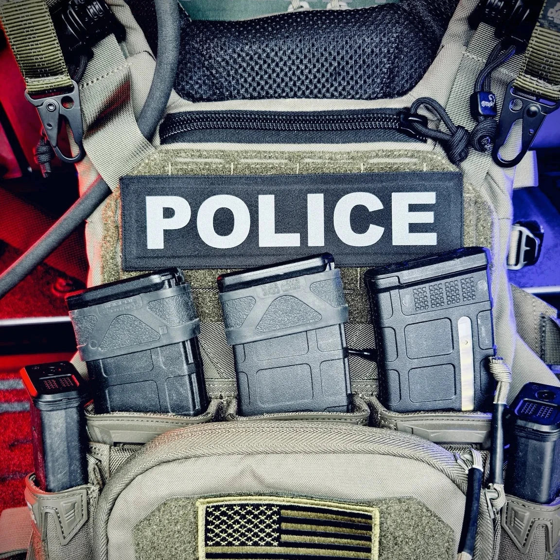 Police tactical vest with various gear and patches on a blurred background