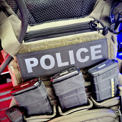 Molle pouch with 'POLICE' patch and various equipment on a tactical vest.