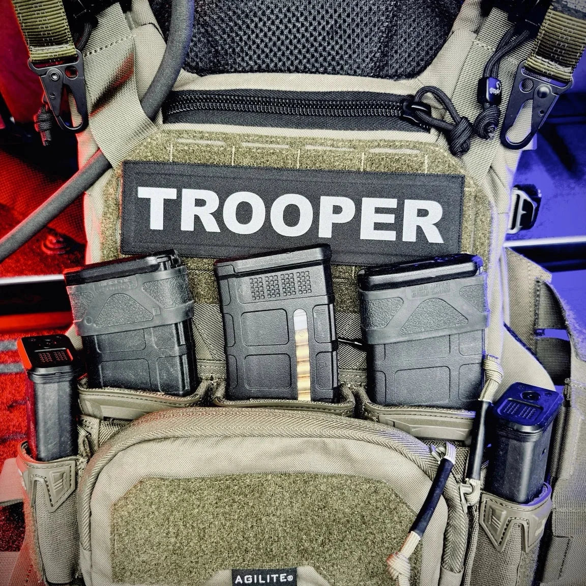 Tactical pouch with 'TROOPER' label and various compartments on a vehicle background