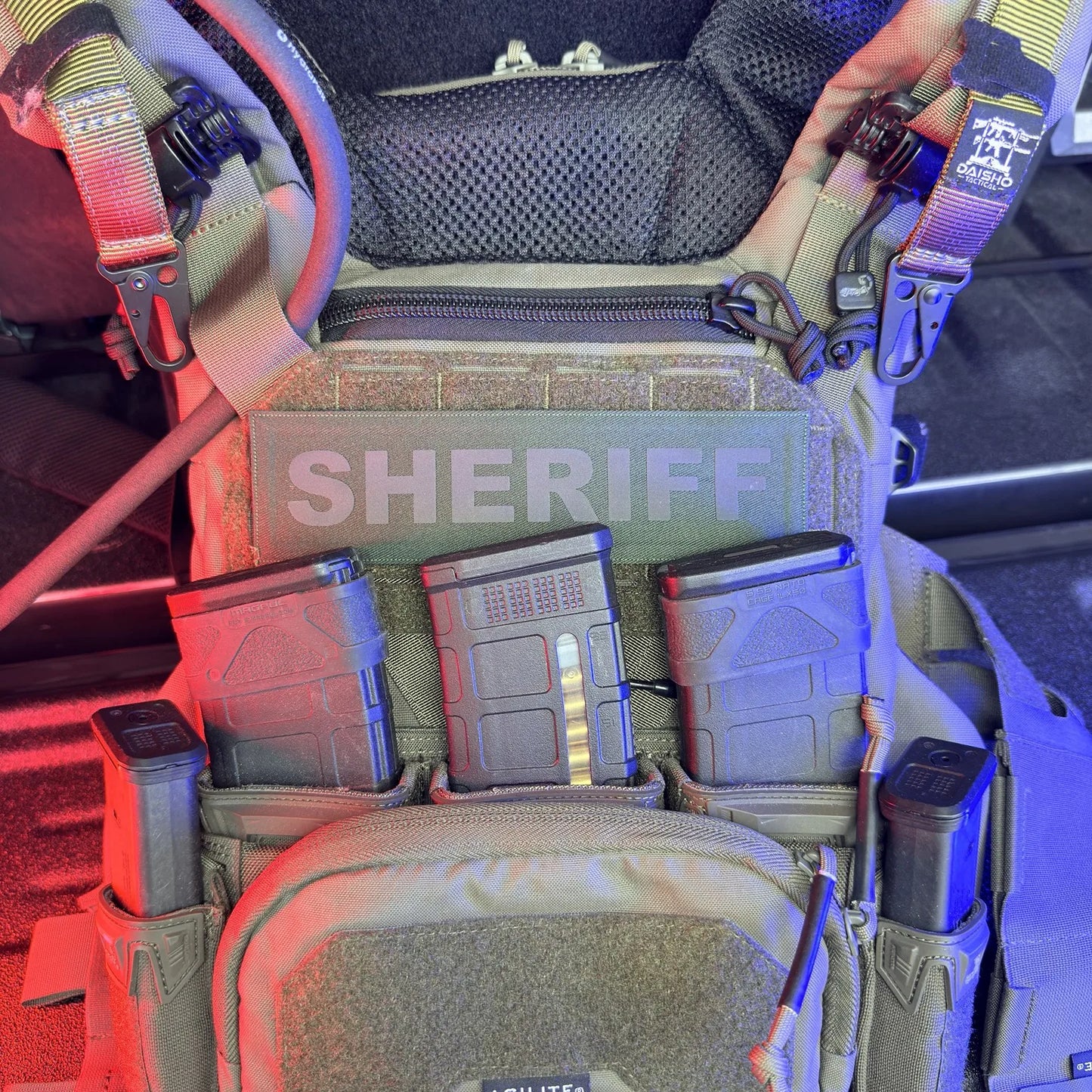 Tactical gear with 'SHERIFF' branding inside a vehicle.