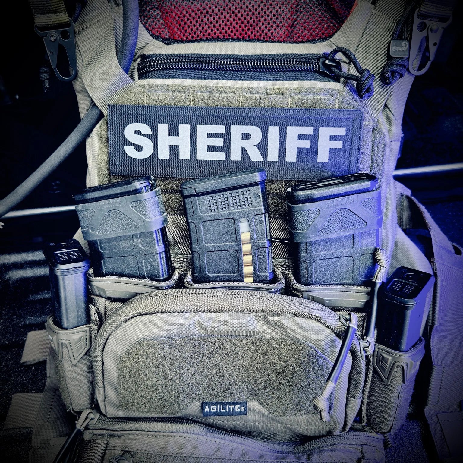 Molle pouch with 'SHERIFF' label and ammunition on a tactical background