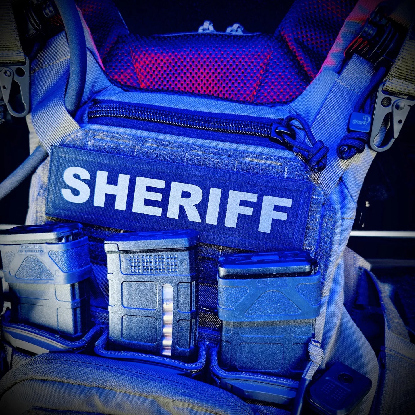 Blue light on a Sheriff vest with various compartments inside a vehicle