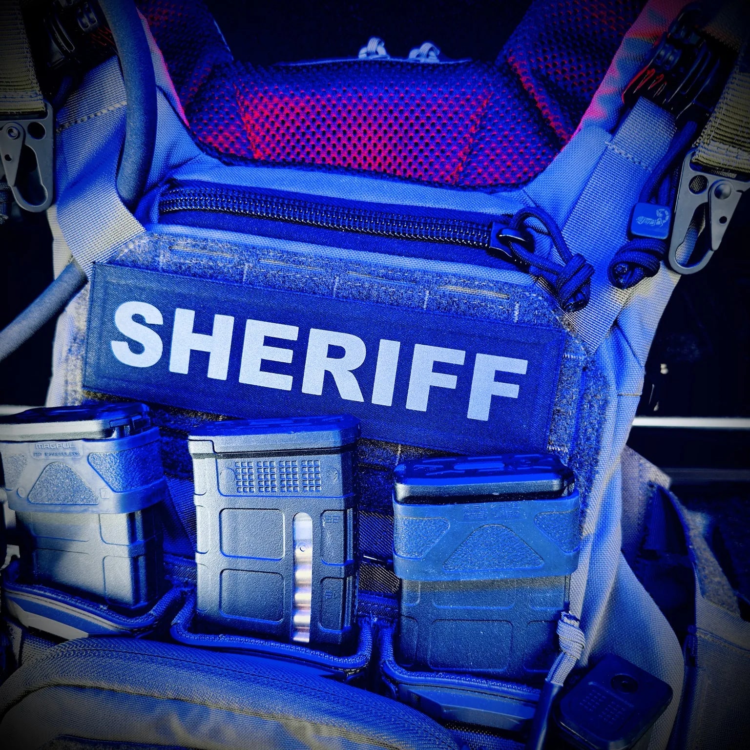 Blue light on a Sheriff vest with various compartments inside a vehicle