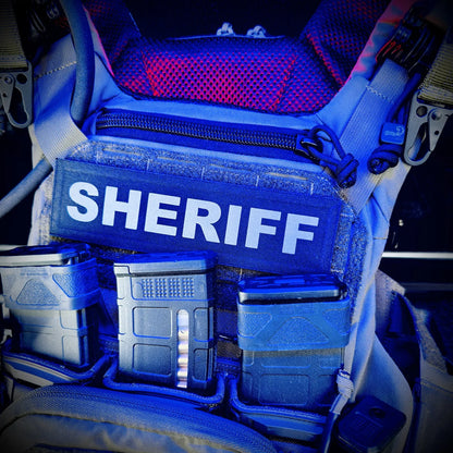 Blue light on a Sheriff vest with various compartments inside a vehicle