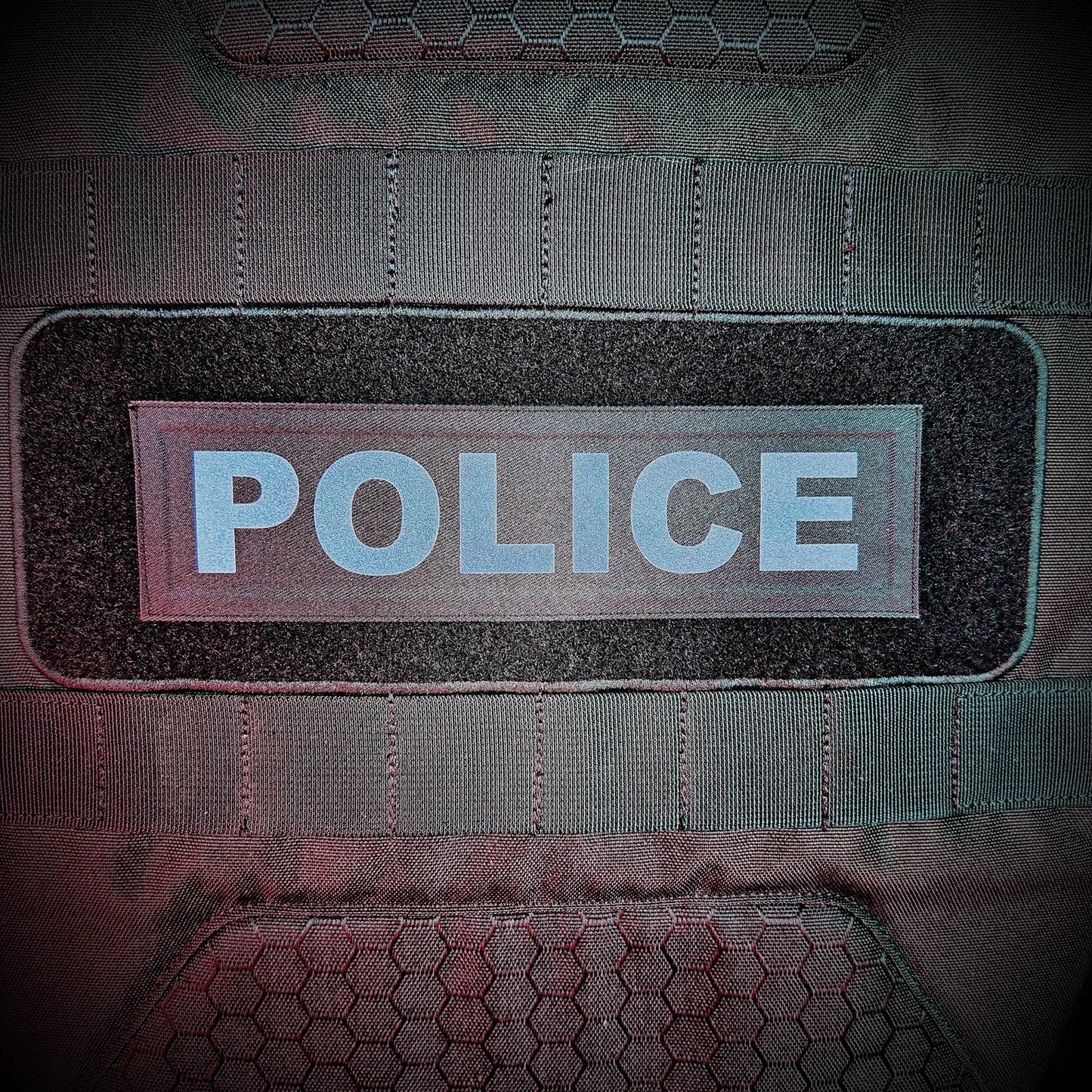 Tactical vest with 'POLICE' patch on a dark background