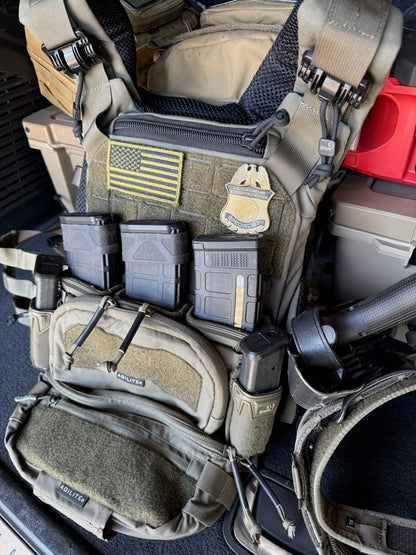 Tactical vest with CBP flex badge and various pouches and equipment inside a vehicle