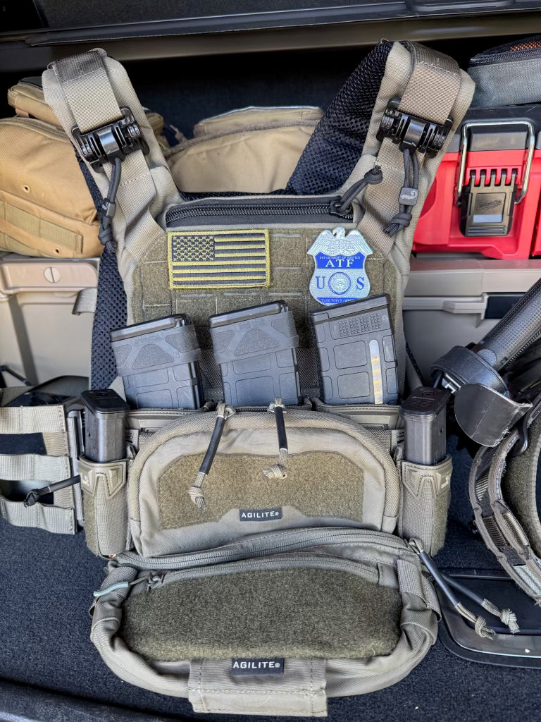 Tactical gear with American flag patch and 'U.S.' label inside a vehicle.