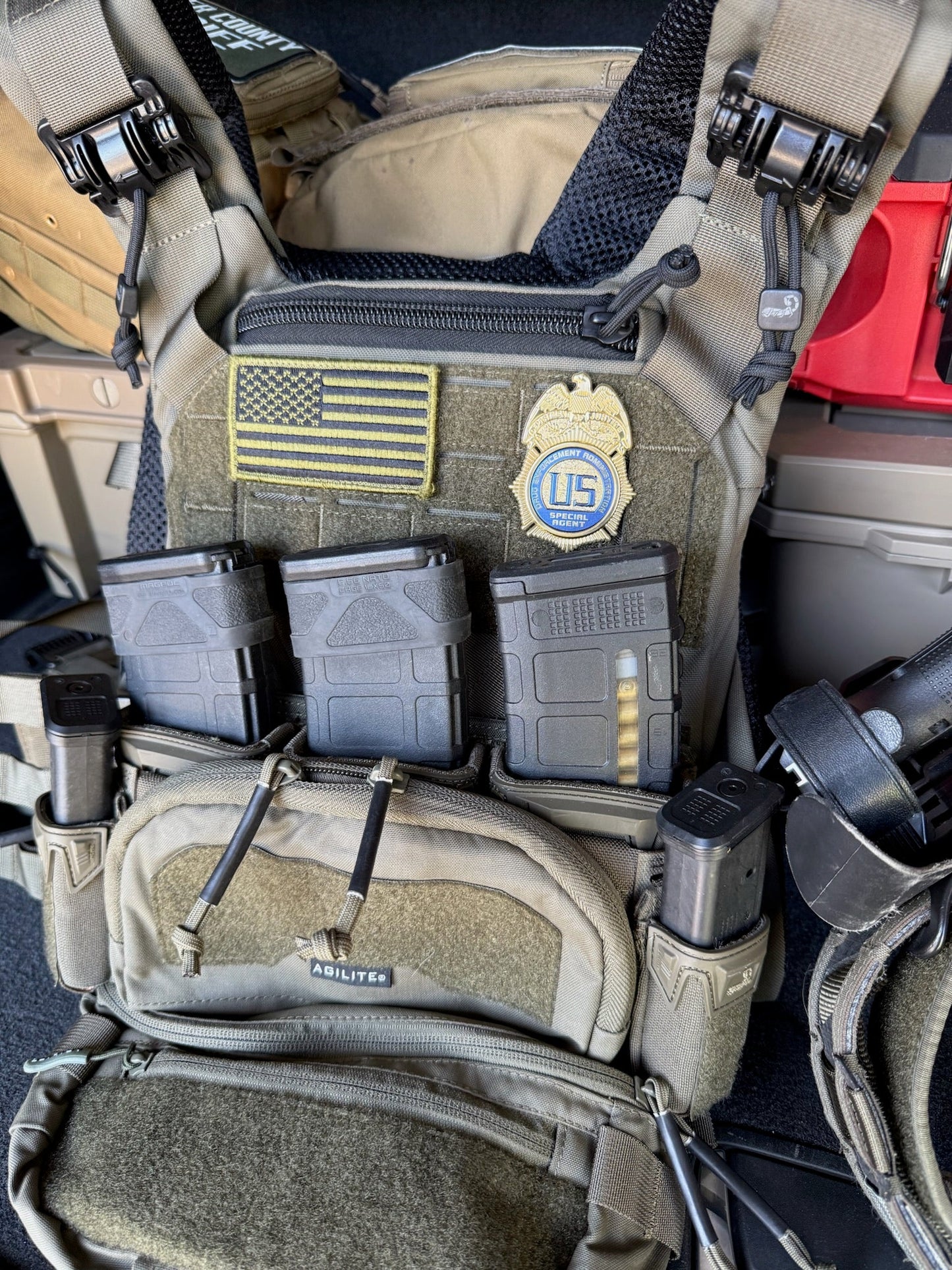 Tactical vest with DEA Flex Badge,  American flag patch, and U.S. emblem.