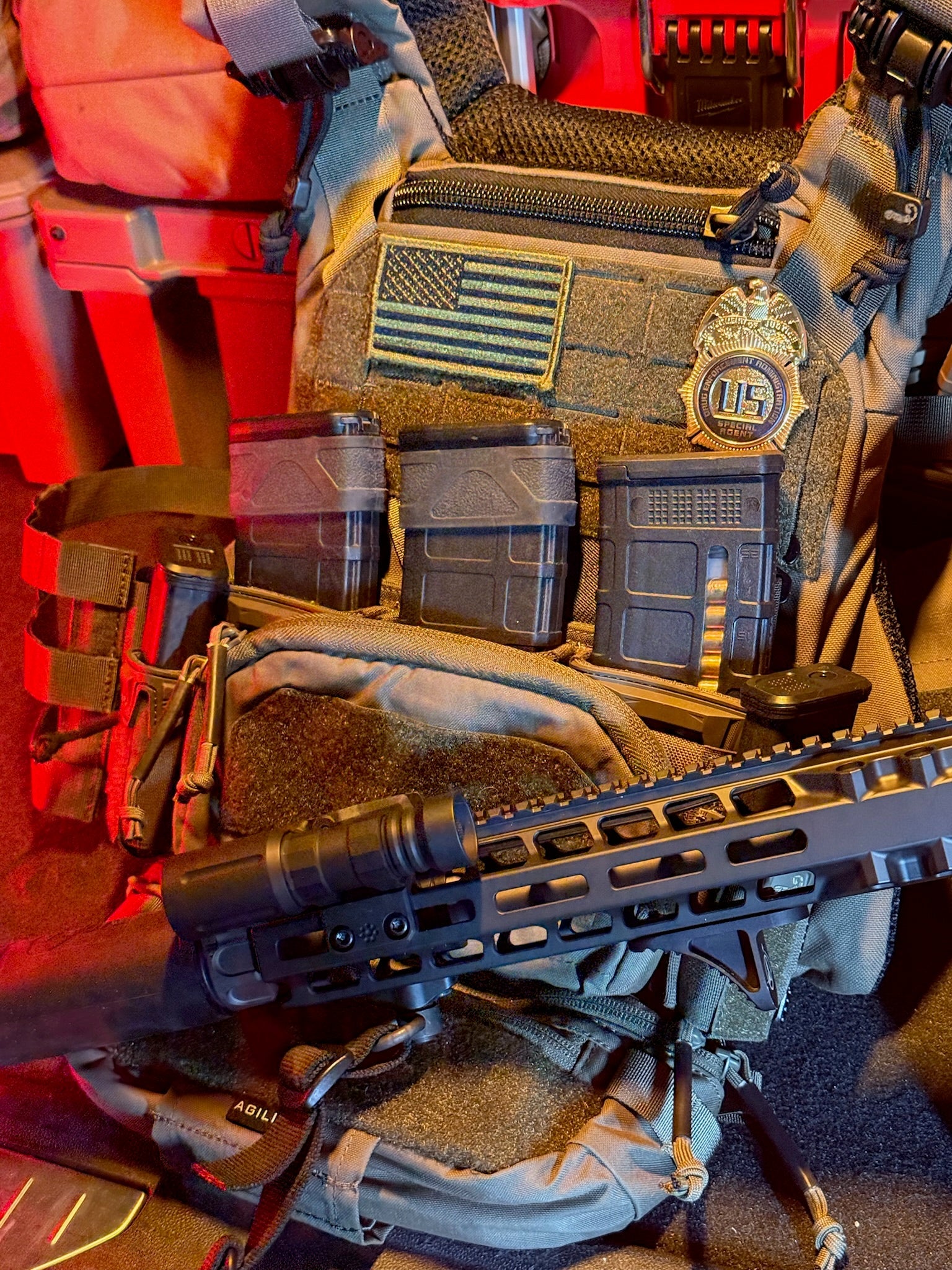 Tactical gear with American flag patch and flex shield badge on tac vest. 