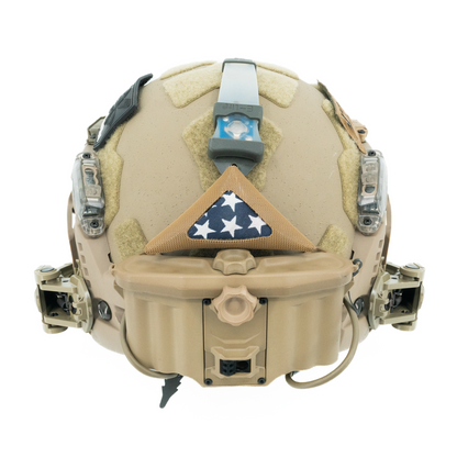 Tan tactical helmet with a flag patch on a white background