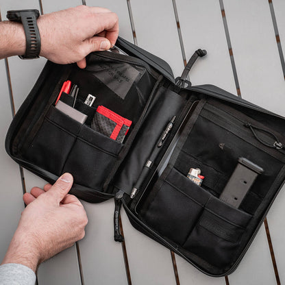 Black travel DAKA organizer with compartments on a wooden surface