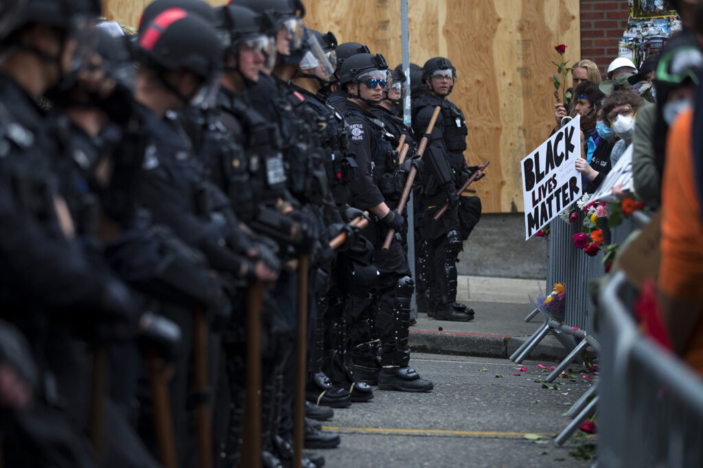 police officers facing BLM rioters