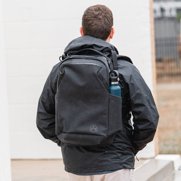 Man wearing the Magpul EDC18 Backpack in black with side water bottle pocket, built for concealed carry and urban readiness